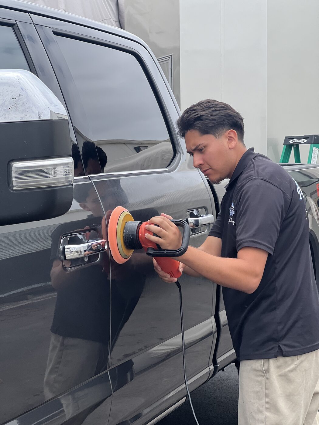 PacificBreeze detailer machine polishing a black SUV door panel